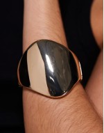 bangle bracelet with large abstract detail in gold tone